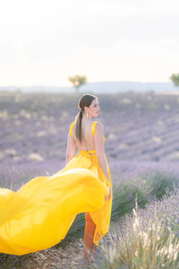 photo de portrait en robe jaune volante au milieu des champs de lavandes